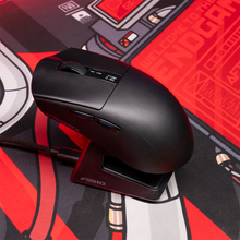 Load image into Gallery viewer, Black Aftershock M1 Pro wireless gaming mouse shown on its RGB charging dock from a high-angle side view, two side buttons.