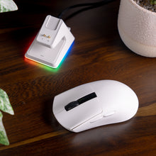 Load image into Gallery viewer, White Aftershock wireless mouse with black scroll wheel and side buttons pictured on a wooden desk next to its white.